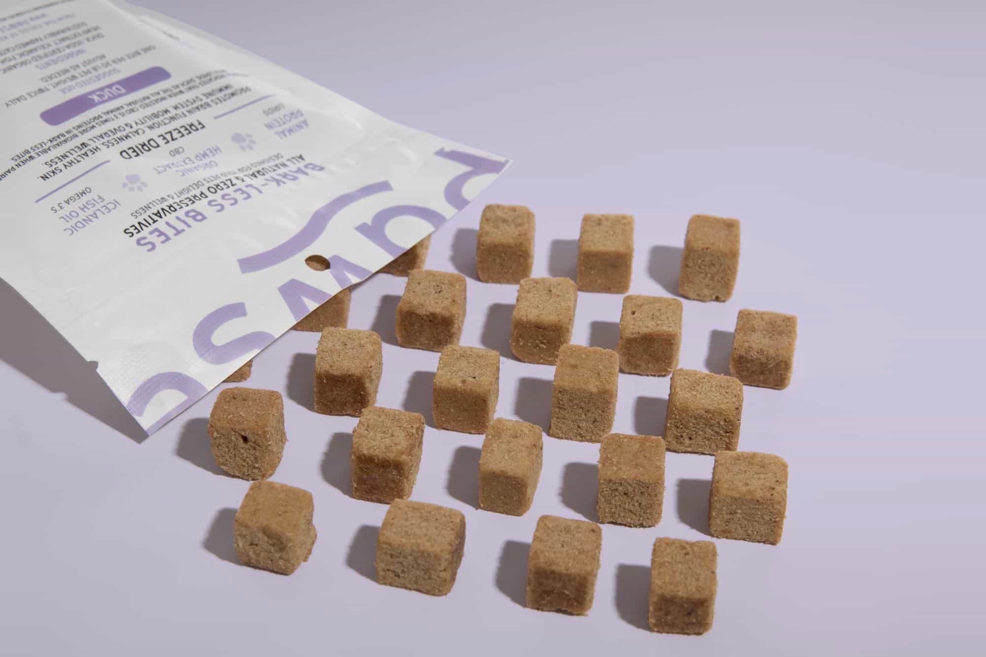 Dog treats spilled from a labeled package onto a surface.